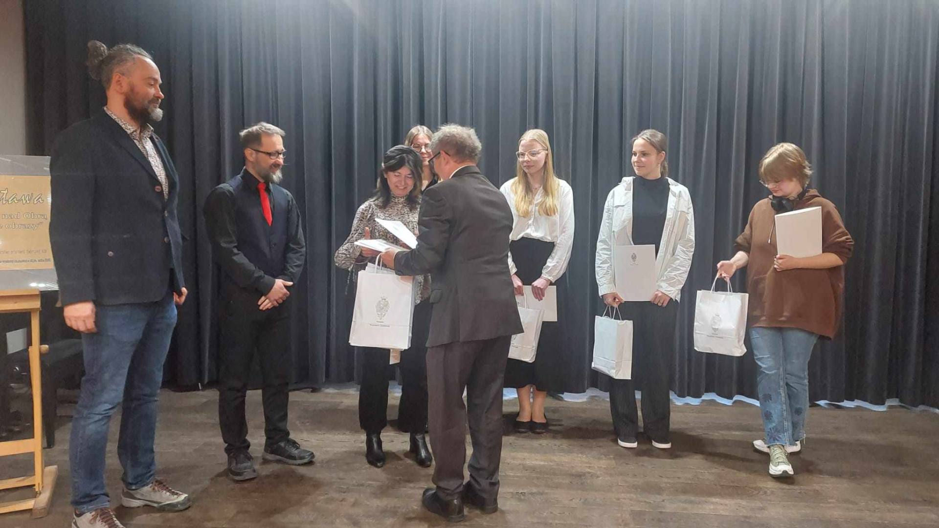 Nagrodę odbiera opiekun merytoryczny Amelii z rąk senatora