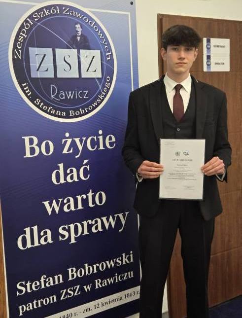 Szymon z dyplomem potwierdzającym tytuł finalisty XXXVIII Olimpiady Wiedzy Ekonomicznej.
