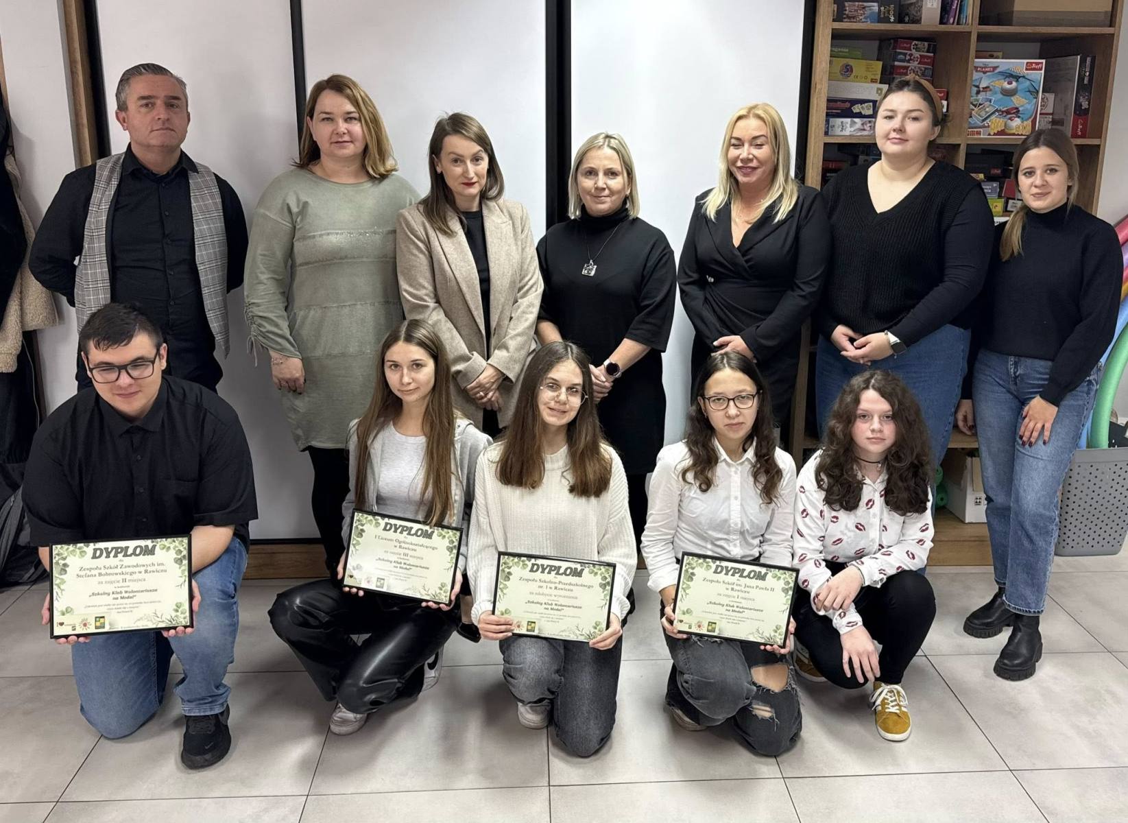 reprezentant wolontariuszy wraz z jednym z opiekunów wolontariatu ks. Krystianem podczas odbioru okolicznościowego dyplomu i nagrody dla całego Koła - zdjęcie grupowe