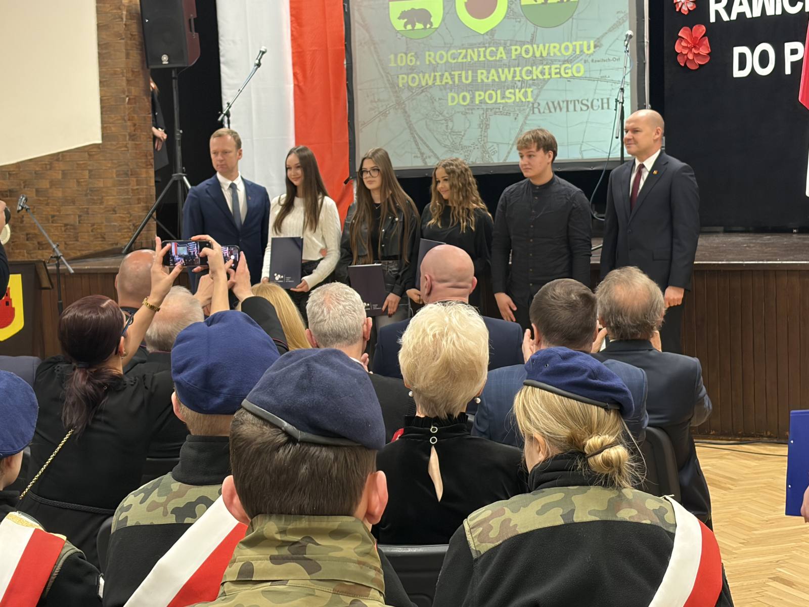 Uczniowie ZSZ w Rawiczu wraz z pocztem sztandarowym podczas odbioru nagród konkursu „Śladami historii Ziemi Rawickiej”